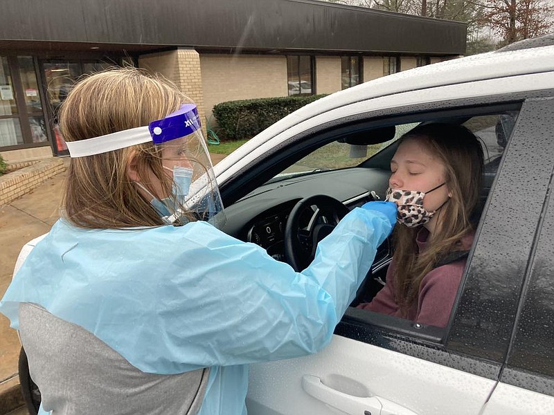 Emma Doggett, then a sophomore at White Hall High School, is tested for covid-19 by district nurse Kelly Andrews in this Thursday, Jan. 7, 2021 file photo. Doggett was there with her mother, Brooke Doggett, who works at the high school. (Pine Bluff Commercial/Byron Tate)