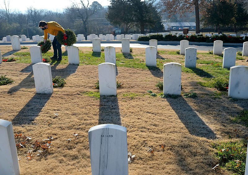 Zackary Jackson of Fayetteville, a veteran of the U.S. Army, collects wreaths Saturday while collecting the holiday wreaths at the Fayetteville National Cemetery. The wreaths were placed in front of each grave in the cemetery in December by volunteers through the Wreaths Across America program and were collected by groups of volunteers organized by the Fayetteville National Cemetery Advisory Council who worked in shifts because of the pandemic. Visit nwaonline.com/210110Daily/ for today’s photo gallery.

(NWA Democrat-Gazette/Andy Shupe)