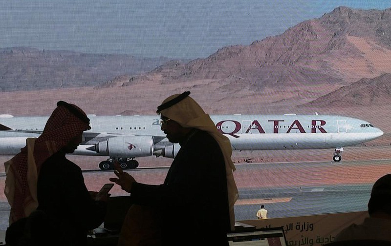 Journalists chat as video of a plane carrying Qatari Emir Sheikh Tamim bin Hamad Al Thani is shown on a screen while landing at at Al Ula airport this week before the start of the Gulf Cooperation Council meeting in Saudi Arabia.
(AP/Amr Nabil) story.lead_photo.caption