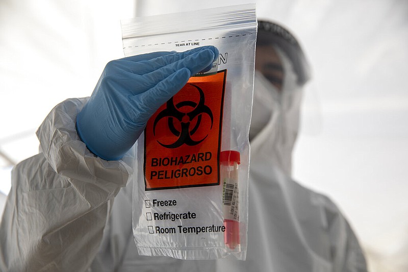 A health care professional holds a covid-19 test sample in a bag at a testing center in Jerusalem on Sunday, Jan. 10, 2021.