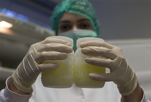 A lab technician shows containers of frozen human milk at the Fernandes Figueira Institute in Rio de Janeiro, Brazil, in this Aug. 27, 2014, file photo. Brazil's extensive milk-bank system allows breast-feeding women to donate milk that is pasteurized and used in neo-natal facilities.