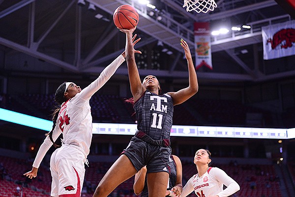 Texas A&M's Kayla Wells (11) shoots over Arkansas' Taylah Thomas (24) during a game Sunday, Jan. 10, 2021, in Fayetteville.