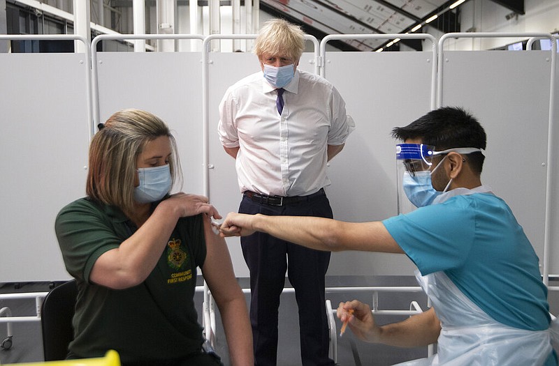 Britain's Prime Minister Boris Johnson watches first responder Caroline Cook receiving an injection of a Covid-19 vaccine at Ashton Gate Stadium in Bristol, England, Monday Jan. 11, 2021. The center is one of the seven mass vaccination centers now opened to the general public as the government continues to ramp up the vaccination programme against Covid-19. story.lead_photo.caption