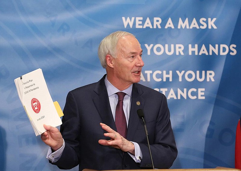Gov. Asa Hutchinson shows off the vaccine response plan during the weekly COVID-19 press conference on Tuesday, Jan. 12, at the state Capitol in Little Rock. (Arkansas Democrat-Gazette/Thomas Metthe)