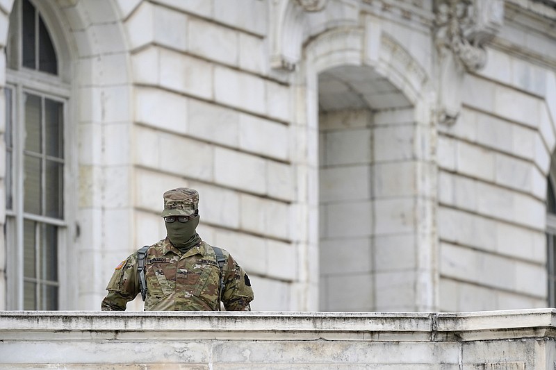 A member of the military stands guard outside Russell Senate Office Building on Capitol Hill in Washington, Friday, Jan. 8, 2021, in response to supporters of President Donald Trump who stormed the U.S. Capitol. 