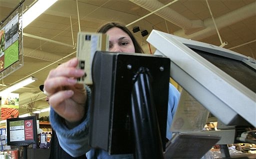 Danielle Ambord slides her debit card into a reader as she pays for groceries in Seattle in this undated file photo.