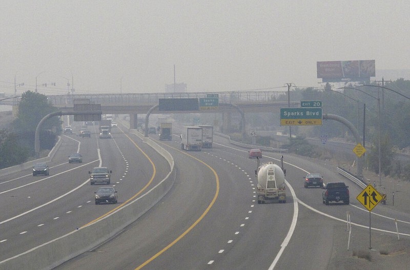 FILE - In this Wednesday, Aug. 19, 2020. file photo, smoke from California wildfires up to 200 miles away obscures the view of traffic traveling on Interstate 80, looking west in Sparks, Nev. Local schools canceled all outdoor activities as the air quality index approached the "very unhealthy" category for the general population Wednesday afternoon. (AP Photo/Scott Sonner)

