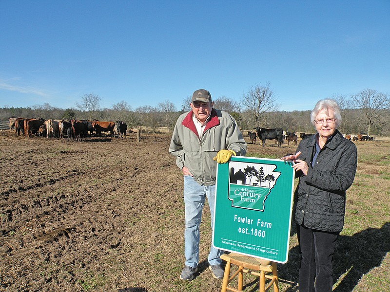 Robert E. Fowler and his wife, Libby Tillman Browne Fowler, of Perry County were among 30 families inducted into the Arkansas Century Farm Program in 2020. Each farm received a sign like the one the Fowlers are holding. The Fowlers, whose ancestors established the farm in 1860, now raise cattle on more than 500 acres in Perry County.