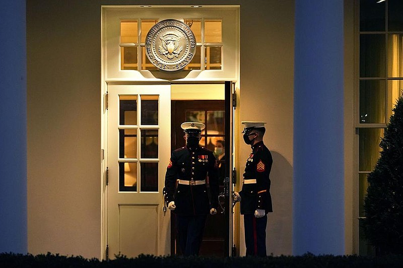 Two Marines change guard duty Wednesday evening at the entrance to the West Wing of the White House. The guard’s presence signifies that the president is in the Oval Office.
(AP/Gerald Herbert) story.lead_photo.caption