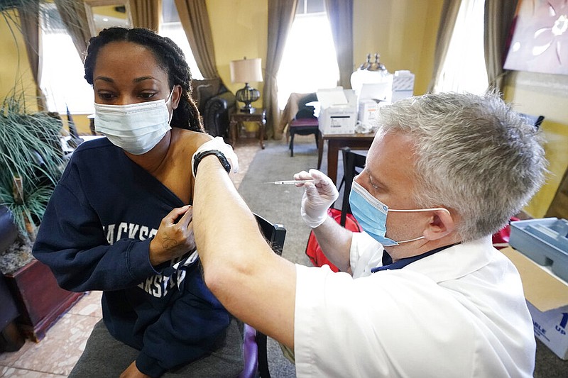 FILE - In this Jan. 12, 2021, file photo, Walgreens pharmacist Chris McLaurin prepares to vaccinate Lakandra McNealy, a Harmony Court Assisted Living employee, with the Pfizer-BioNTech covid-19 vaccine in Jackson, Miss.