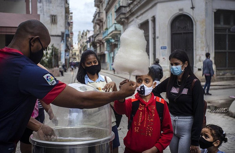 People wait for their turn Monday to buy cotton candy in Havana, Cuba. This year, the Cuban government is implementing financial measures that will reduce subsidies, eliminate a dual currency and raise salaries.
(AP/Ramon Espinosa)