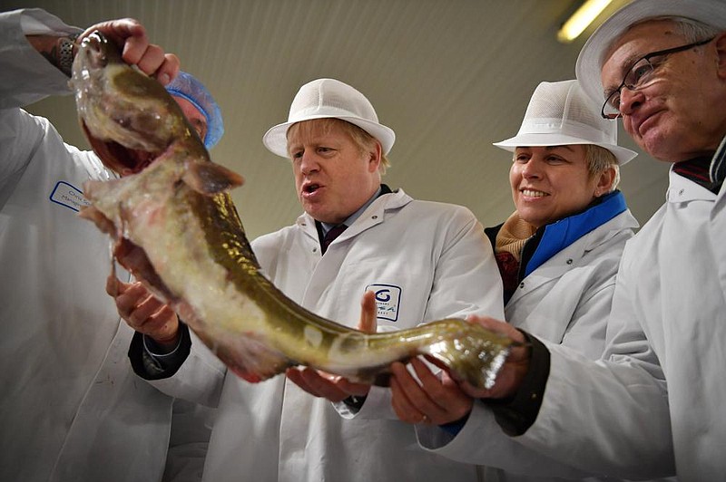 Britain’s Prime Minister and Conservative Party leader Boris Johnson (center) visits a fish market last month in Grimsby in northeast England. British fishing communities were among the strongest supporters of Brexit, but now some say they face ruin because of new red tape related to the U.K.’s departure from the European Union.
(AP)