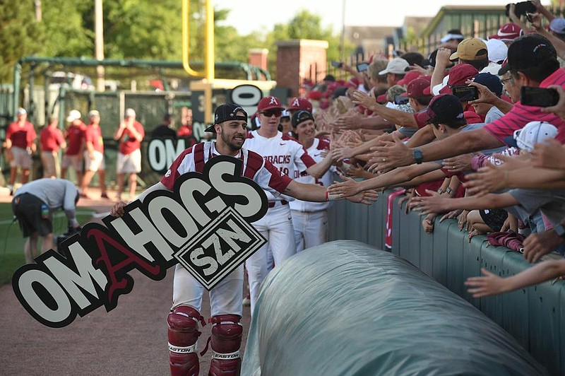 Casey Opitz and other Arkansas baseball players celebrate with fans after a victory in 2019 at Baum-Walker Stadium in Fayetteville. Officials have not set an official number of fans who will be allowed for games this season, but Arkansas officials said they expect that number to be at least 4,000.
(NWA Democrat-Gazette/J.T. Wampler)