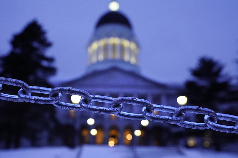 A chain blocks the sidewalk entrance to the front steps of the Maine State House, Wednesday, Jan. 13, 2021, in Augusta, Maine. With the FBI warning of potential violence at all state capitols Sunday, Jan. 17, the ornate halls of government and symbols of democracy looked more like heavily guarded U.S. embassies in war-torn countries. (AP Photo/Robert F. Bukaty)