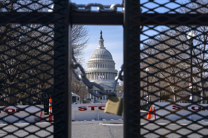 With the U.S. Capitol in the background, a lock on anti-scaling security fencing is seen on Saturday, Jan. 16, 2021, in Washington.