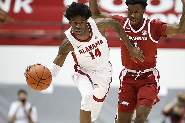 Alabama guard Keon Ellis (14) dribbles the ball up court while being defended by Arkansas guard Davonte Davis during a game Saturday, Jan. 16, 2021, in Tuscaloosa, Ala. (Photo via SEC Pool)