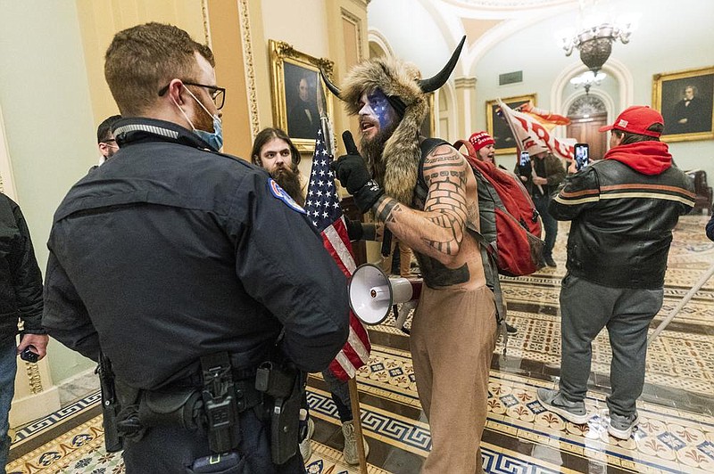 Jacob Anthony Chansley (center), who also goes by the name Jake Angeli, left a threatening note for Vice President Mike Pence when he climbed on the dais where Pence had earlier been presiding over the Electoral College vote when protesters stormed the U.S. Capitol on Jan. 6, U.S. prosecutors said.
(AP/Manuel Balce Ceneta)