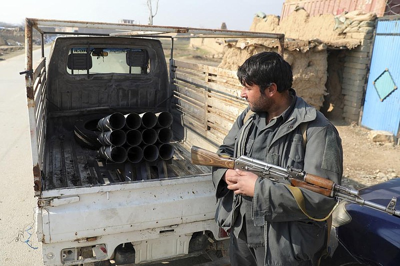 An Afghan security official stands near a vehicle filled with rockets in Bagram last month. The U.S. military had met its goal of reducing the number of troops in Afghanistan to about 2,500 by Friday.
(AP/Rahmat Gul)