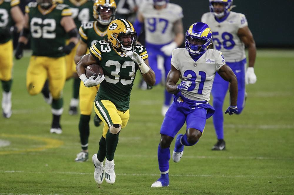 Green Bay Packers running back Aaron Jones (33) runs the ball as Los Angeles Rams cornerback Darious Williams attempts to catch him Saturday night at Lambeau Field in Green Bay, Wis. Jones rushed for 99 yards and a touchdown on 14 carries to help the Packers to a 32-18 victory over the Rams.
(AP/Matt Ludtke)