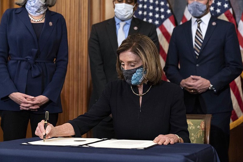 House Speaker Nancy Pelosi signs the article of impeachment against President Donald Trump in an engrossment ceremony Wednesday before transmission to the Senate for trial.
(AP/Alex Brandon)