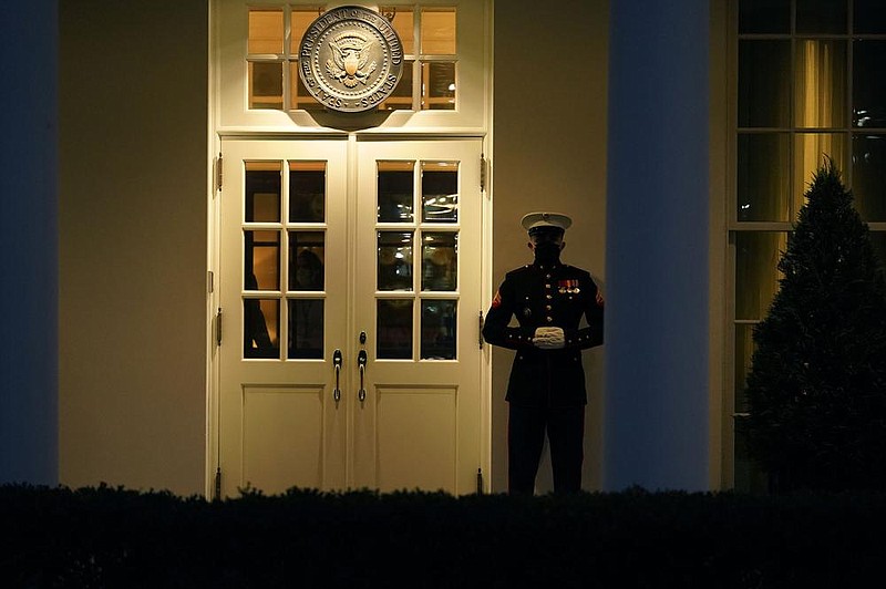 A Marine guard stands Wednesday evening at the entrance to the West Wing of the White House, signifying President Donald Trump was in the Oval Office, after the House impeached Trump.
(AP/Gerald Herbert)