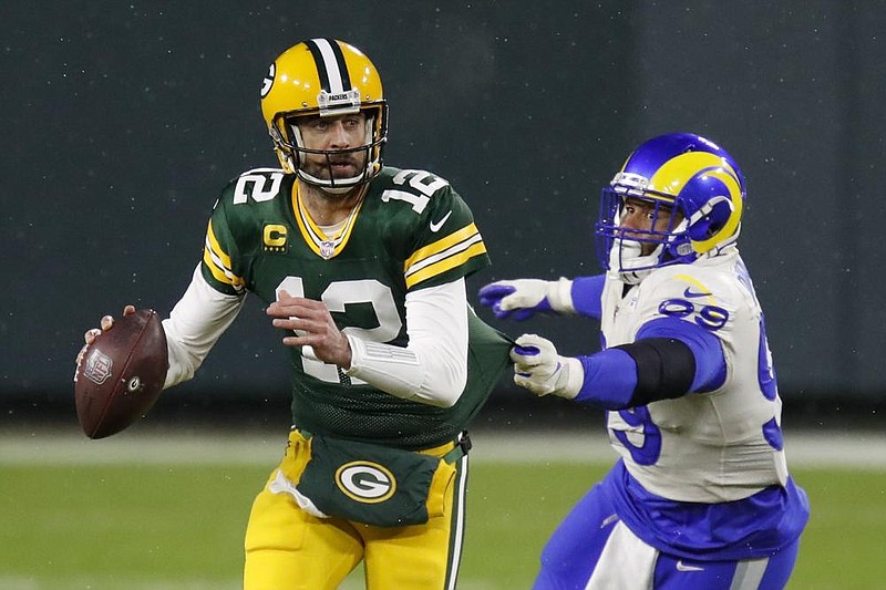 Green Bay Packers quarterback Aaron Rodgers throws under pressure from Aaron Donald of the Los Angeles Rams during the first half of Saturday’s NFC divisional playoff game in Green Bay, Wis. More photos available at arkansasonline.com/117lagreen.
(AP/Matt Kudtke)