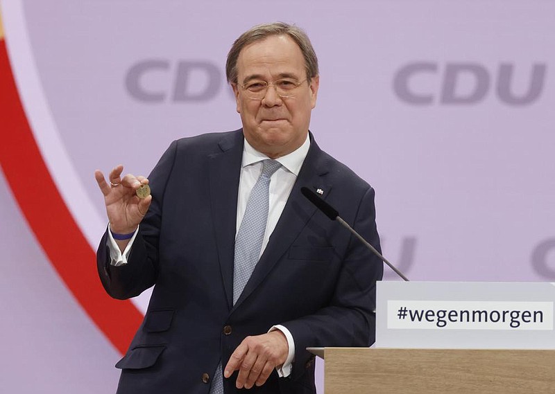 Armin Laschet, governor of Germany’s North Rhine-Westphalia state, delivers a speech Saturday during the Christian Democratic Union’s virtual congress, showing a coin offered by his father for luck.
(AP/Odd Andersen)