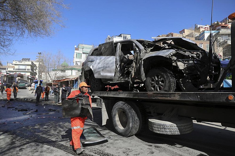 Afghan security forces remove a damaged vehicle Saturday after bombing in Kabul. More photos at arkansasonline.com/117kabul/.
(AP/Rahmat Gul)