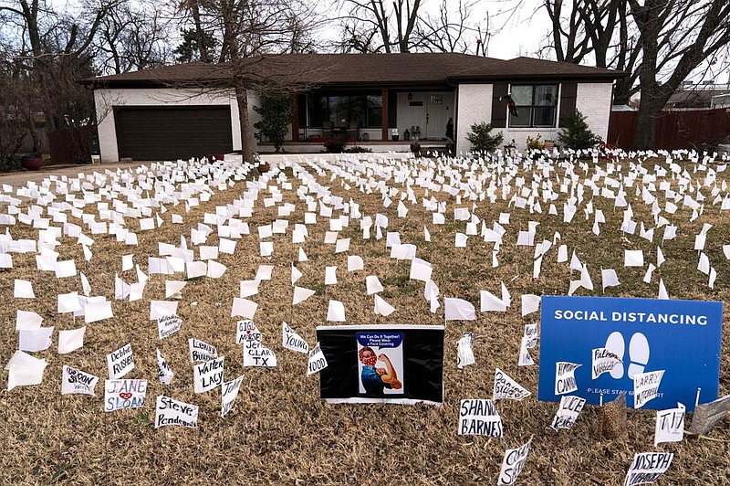 A makeshift memorial of white flags representing Oklahomans who have died of covid-19 fills a front yard Saturday in Yukon, Okla. More photos at arkansasonline.com/117covid19/.
(The New York Times/Nick Oxford)