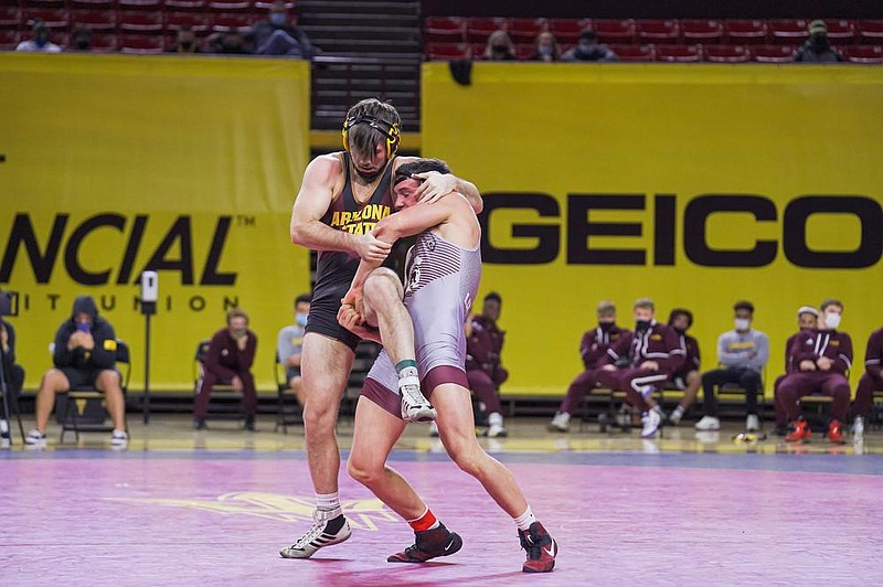 UALR’s Triston Wills (right), shown competing against Arizona State on Jan. 2, underwent brain surgery after suffering an injury before his sophomore year of high school in Kansas. He returned to the mat six months later and eventually won two state championships before signing with Oklahoma State and then transferring to UALR.
(Photo courtesy of UALR)