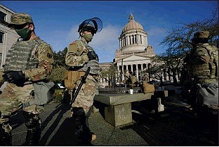 Members of the Washington National Guard stand at a sundial near the Legislative Building on Jan. 10 at the Capitol in Olympia, Wash. Governors in some states have called out the National Guard, declared states of emergency and closed their capitols over concerns about potentially violent protests. Though details remain murky, demonstrations are expected at state capitols beginning Sunday and leading up to President-elect Joe Biden’s inauguration on Wednesday.