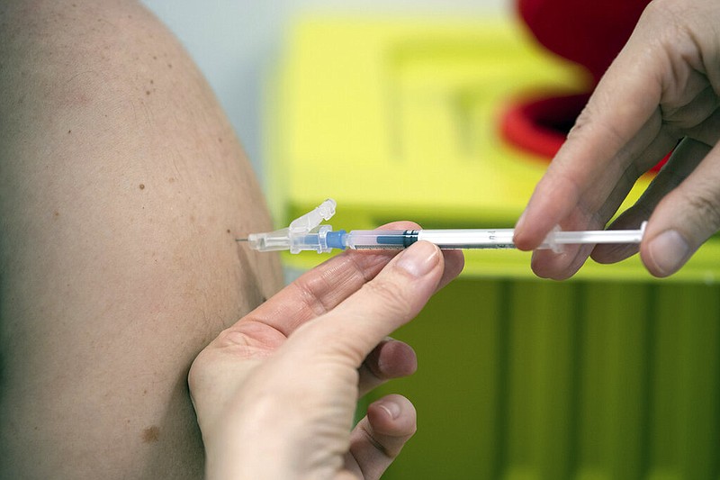 A member of staff at the university hospital injects the Moderna vaccine against covid-19 into a patient in Duesseldorf, Monday, Jan. 18, 2021. (Federico Gambarini/dpa via AP)
