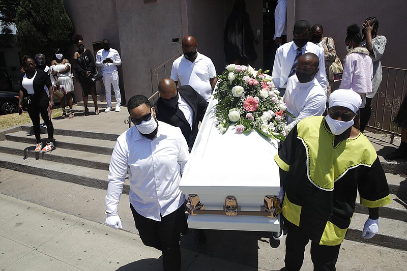 FILE - In this July 21, 2020, file photo, pall bearers carry a casket with the body of Lydia Nunez, who died from covid-19, after a funeral service at the Metropolitan Baptist Church in Los Angeles.