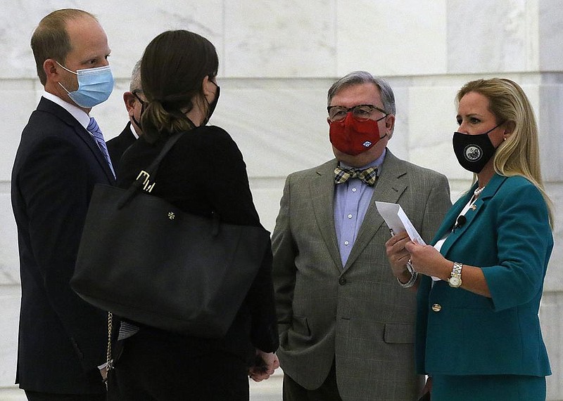 Arkansas Attorney General Leslie Rutledge (right) talks with her staff before announcing Doyle Webb (right center) Douglas House and Andy Davis (left) would serve on the AG's redistricting team during a press conference on Tuesday, Jan. 19, 2021, at the state Capitol in Little Rock. 
(Arkansas Democrat-Gazette/Thomas Metthe)