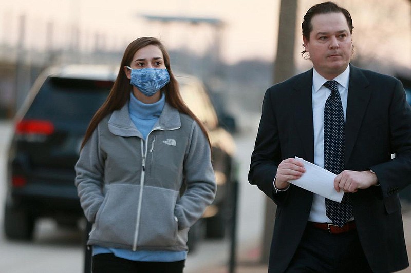 Emily Hernandez, left, who is accused of being in the U.S. Capitol during the Jan. 6 riot, and stealing a broken sign that identified House Speaker Nancy Pelosi's office, turns herself into the St. Louis FBI office, with her attorney Ethan Corlija, Tuesday, Jan. 19, 2021. Hernandez, 21, of Sullivan, appeared via video for the initial appearance. She was released without bond to await her next court appearance, which will be in Washington D.C. (Christian Gooden/St. Louis Post-Dispatch via AP)