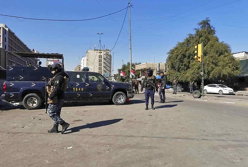 Security forces gather at the site of a deadly bomb attack in Baghdad's bustling commercial area, Iraq, Thursday, Jan. 21, 2021. Twin suicide bombings hit Iraq's capital Thursday killing and wounding civilians, police and state TV said. (AP Photo/Hadi Mizban)