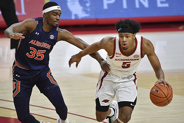 Arkansas guard Moses Moody (5) tries to get past Auburn defender Devan Cambridge (35) during the first half of an NCAA college basketball game Wednesday, Jan. 20, 2021, in Fayetteville. (AP Photo/Michael Woods)