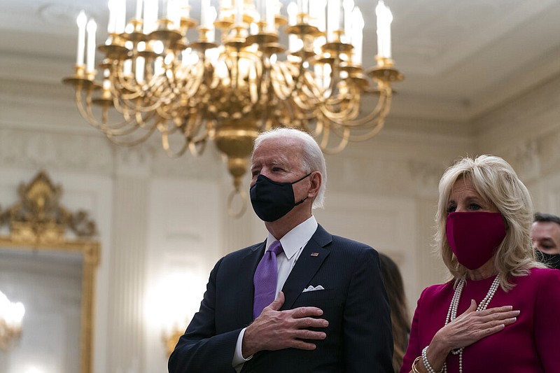 President Joe Biden, accompanied by first lady Jill Biden, places his hand over his heart during a performance of the national anthem, during a virtual Presidential Inaugural Prayer Service in the State Dinning Room of the White House, Thursday, Jan. 21, 2021, in Washington.