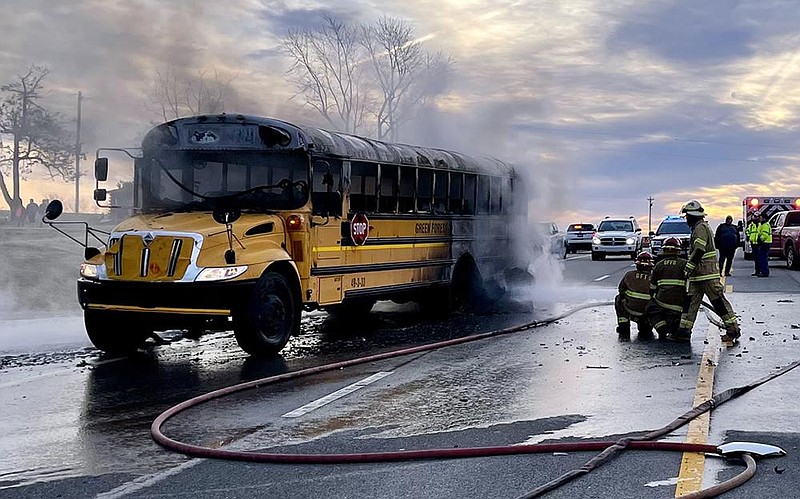 First responders handle a school bus fire Wednesday after a car rear-ended the bus while it was stopped picking up children on U.S. 62 near Green Forest in Carrol County. The driver of the car was killed in the crash.
(Special to the Arkansas Democrat-Gazette/John Bailey)