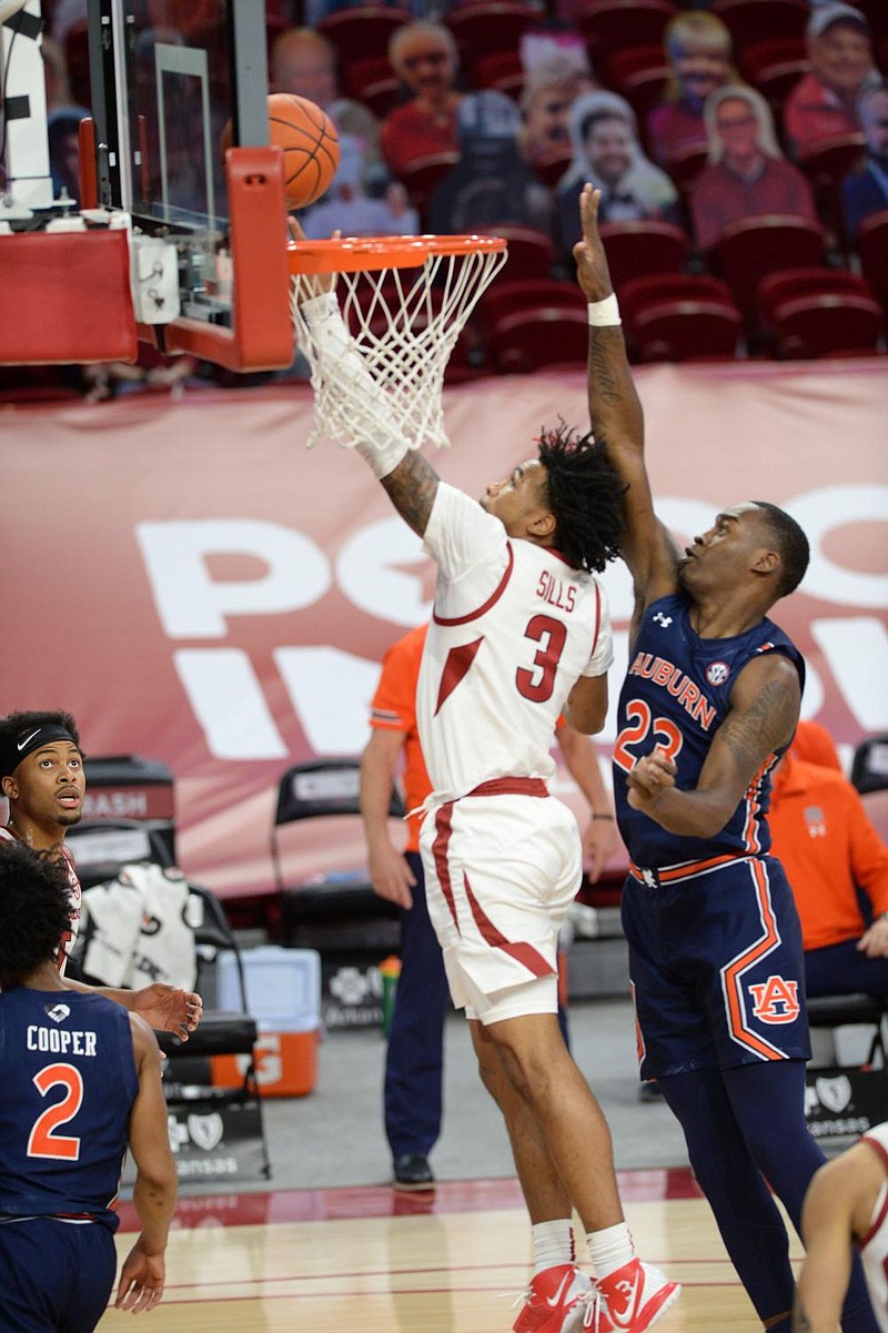 Arkansas guard Desi Sills shoots a layup Wednesday in front of Auburn forward Jaylin Williams during the Razorbacks’ victory in Fayetteville. Sills finished with 22 points. More photos at arkansasonline.com/121uaau/.
(NWA Democrat-Gazette/Andy Shupe)