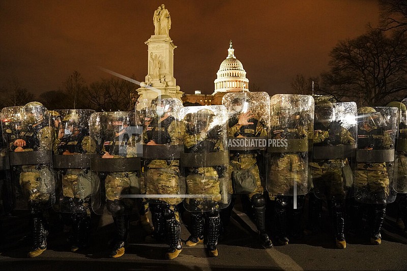 District of Columbia National Guard stand outside the Capitol, Wednesday night, Jan. 6, 2021, after a day of rioting protesters. It's been a stunning day as a number of lawmakers and then the mob of protesters tried to overturn America's presidential election, undercut the nation's democracy and keep Democrat Joe Biden from replacing Trump in the White House. 