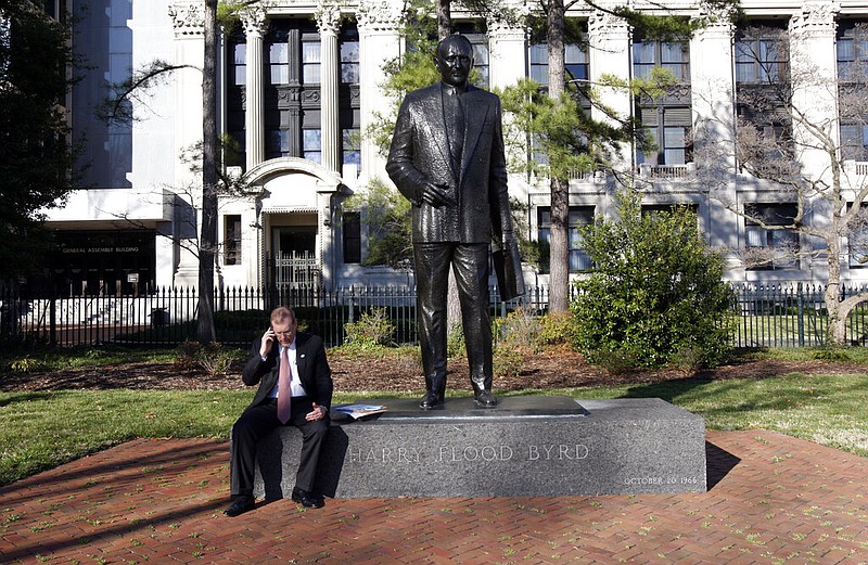 Virginia House Majority Leader H. Morgan Griffith, R-Salem, talks on a phone as he sits at the feet of the statue of Harry F. Byrd at Capitol Square in Richmond, Va., in this Saturday, March 13, 2010, file photo. Byrd, a former Virginia governor and U.S. senator, was a staunch segregationist and the architect of massive resistance against integrating schools. His family is not related to the family of the late U.S. Sen. Robert Byrd of West Virginia.