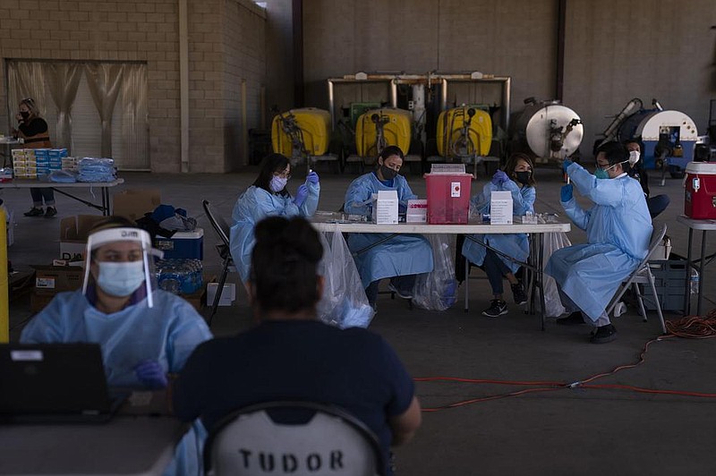 Medical workers prepare the Pfizer-BioNTech covid-19 vaccine for farmworkers Thursday at Tudor Ranch in Mecca, Calif. State health officials cleared the use of a batch of Moderna vaccine Thursday after a pause because of allergic reactions at one site.
(AP/Jae C. Hong)