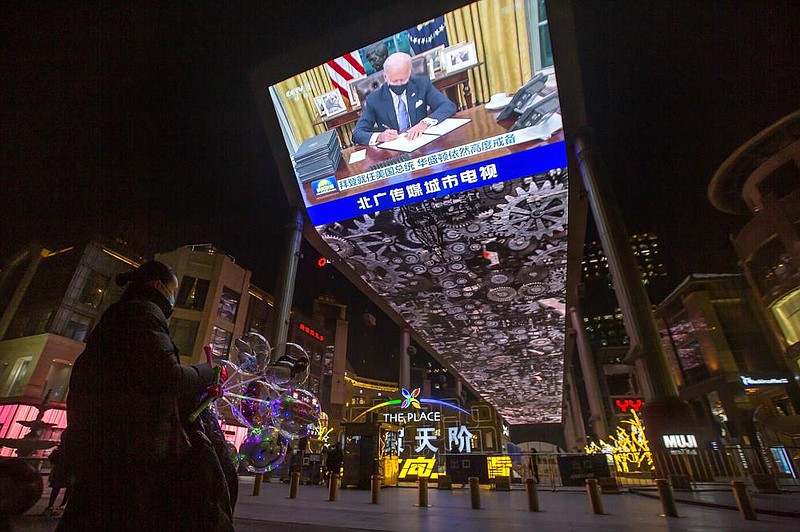 A vendor selling lighted balloons stands Thursday near a large video at a shopping mall in Beijing showing a government news report about the inauguration of President Joe Biden.
(AP/Mark Schiefelbein)