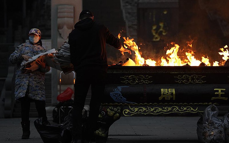 Residents in Wuhan, China, burn paper offerings Friday for a relative who died from the coronavirus. Wuhan is the central Chinese city where the coronavirus was first detected nearly a year ago. More photos at arkansasonline.com/123covid19/.
(AP/Ng Han Guan)