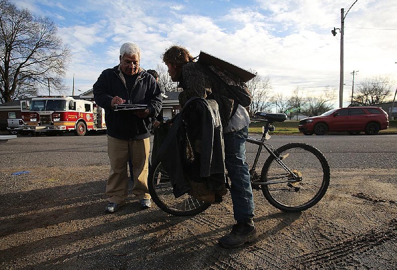 Volunteer Victor Moya jots down information from Kevin Teer while conducting a count of homeless people on Roosevelt Road in Little Rock in this January 2019 file photo.