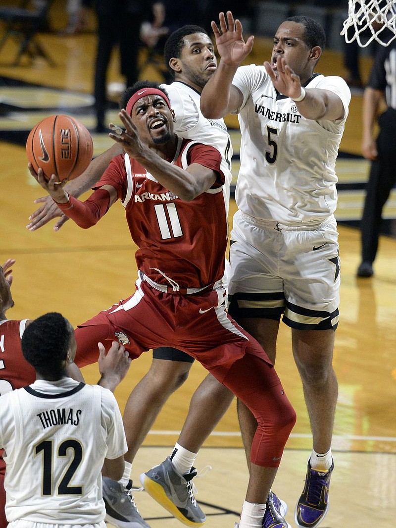 Arkansas senior guard Jalen Tate (11) puts up a shot while being defended by Vanderbilt’s D.J. Harvey during the Razorbacks’ victory Saturday at Nashville, Tenn. Tate finished with 25 points, 5 rebounds, 8 assists and 4 steals. More photos available at arkansasonline.com/124uavandy. (AP/Mark Zaleski) 