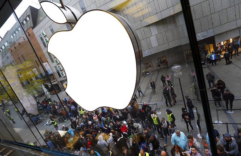 FILE - In this Friday, Sept. 25, 2015, file photo, people wait in front of an Apple store in Munich. (AP Photo/Matthias Schrader, File)

