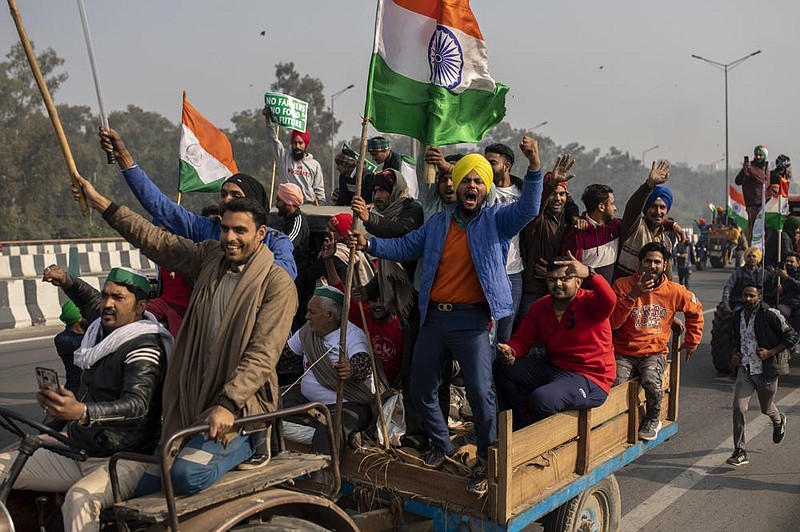 Protesting farmers on tractors shout Tuesday as they ride to the capital, interrupting India’s Repub- lic Day celebrations in New Delhi.
(AP/Altaf Qadri)
