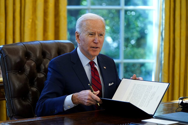 President Joe Biden signs a series of executive orders on health care, in the Oval Office of the White House, Thursday, Jan. 28, 2021, in Washington. 